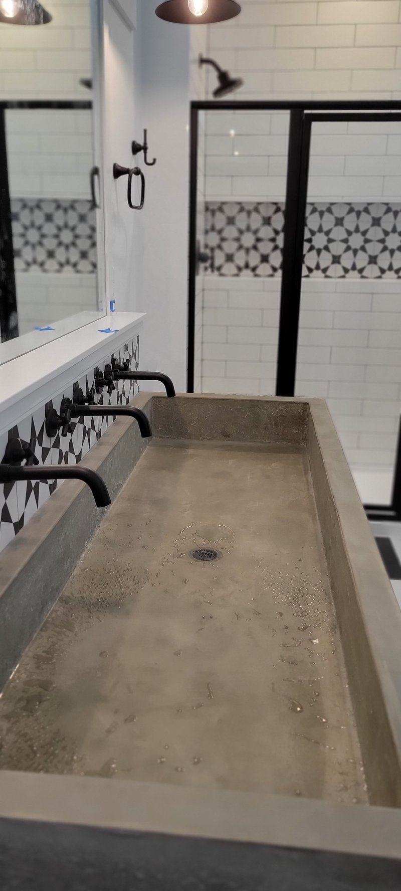 Trough concrete double vanity sink with wall-mounted black faucets