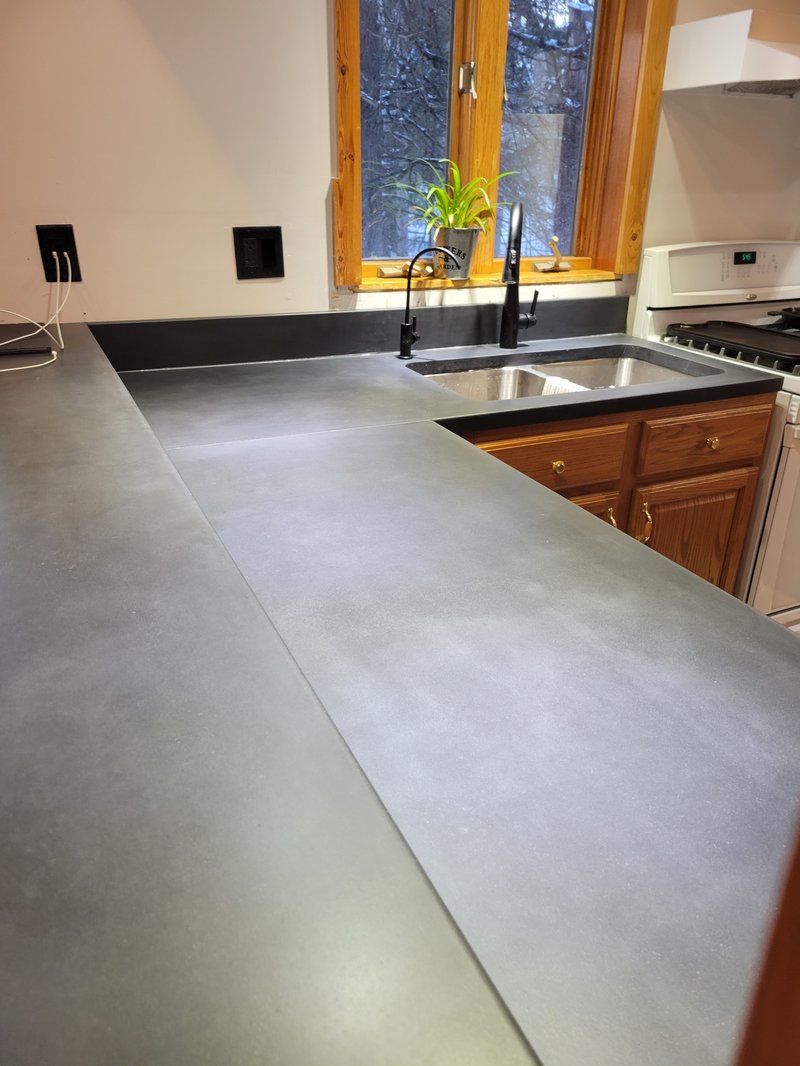 Gray concrete L-shaped kitchen countertop with an undermount sink