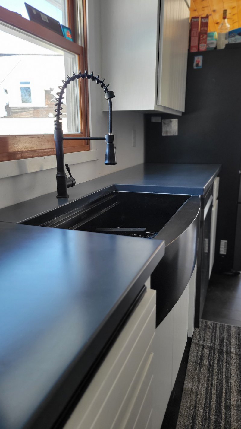 Dark gray concrete kitchen countertop with an integrated apron sink