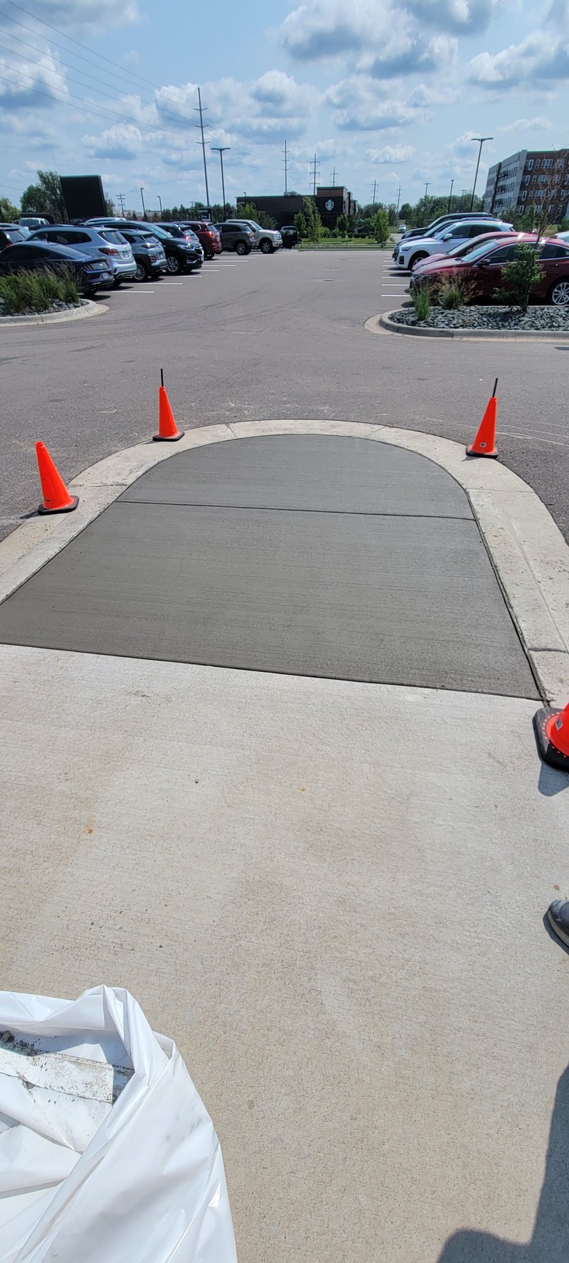 Curved concrete sidewalk ramp in a commercial parking lot