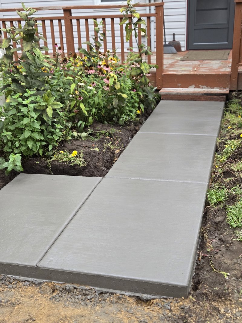 Concrete garden path continuing toward a deck, coneflowers on either side