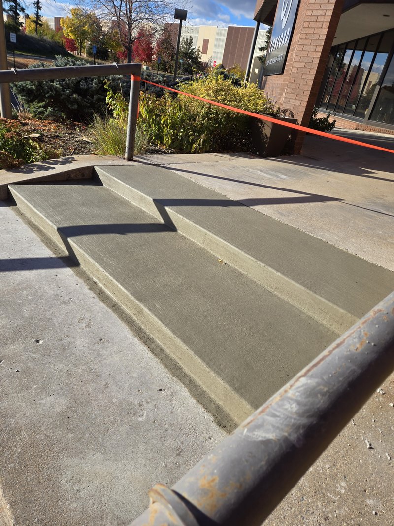 Zigzag exterior concrete steps leading up to a commercial storefront