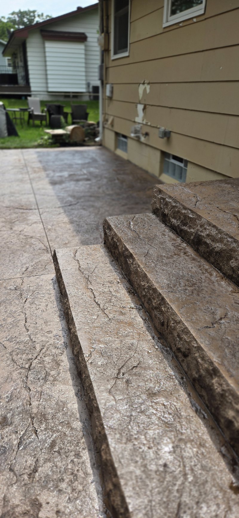 Close-up of stamped stone-textured concrete steps leading up to a patio