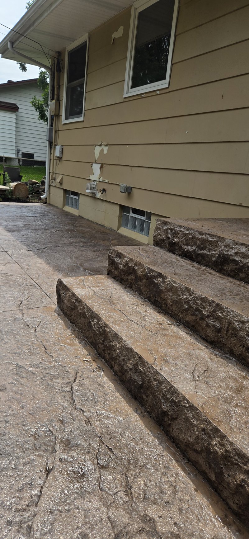 Low-angle view of stamped stone steps beside a tan house