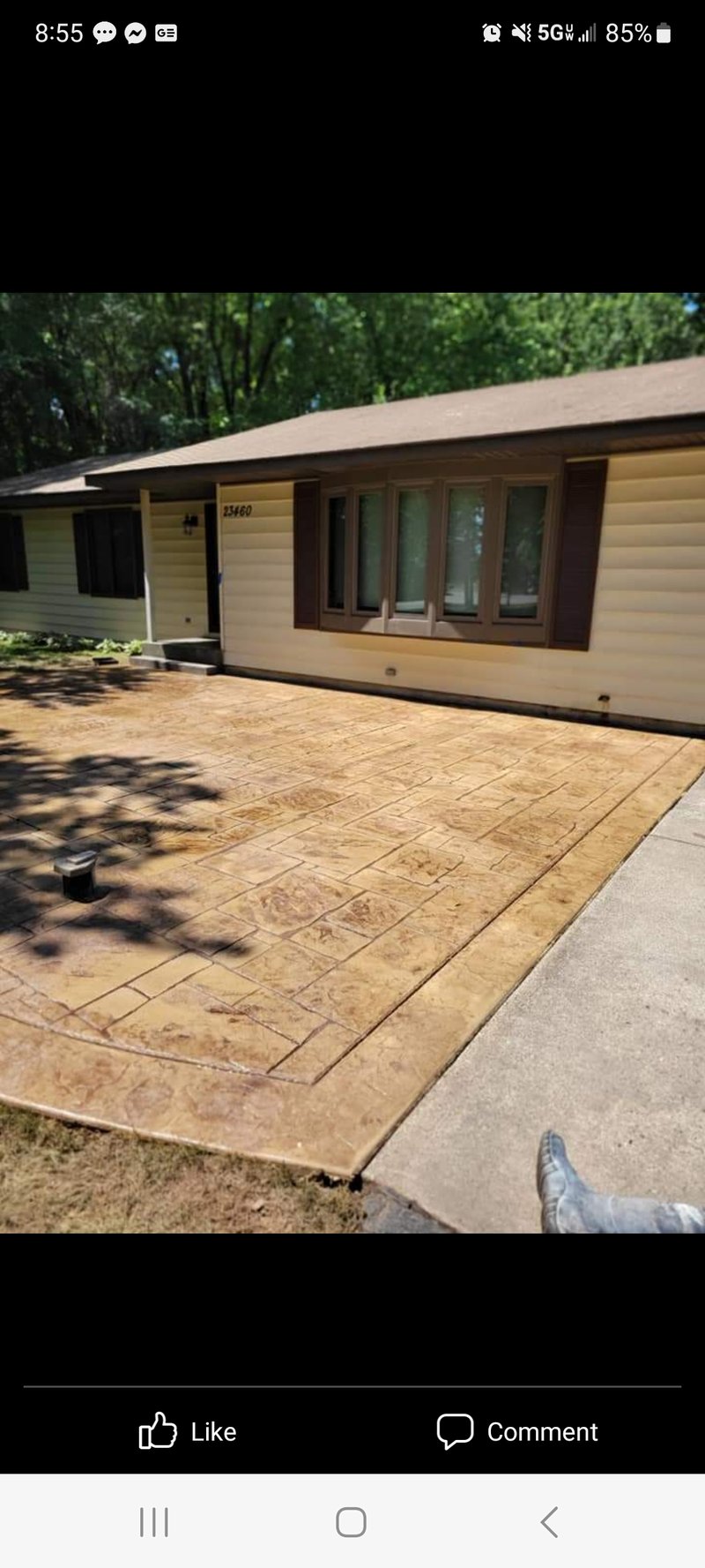 Tan stamped ashlar-pattern concrete driveway in front of a ranch house